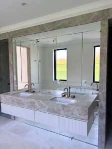 Contemporary bathroom renovation in Rose Bay with freestanding tub, full-height marble wall, custom marble vanity, and brushed bronze tapware.