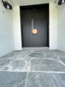 Contemporary new build with arched door and crazy paving